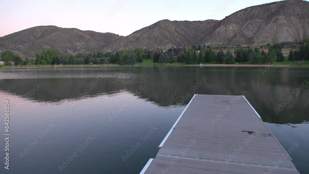 Nottingham lake park dock in Avon, Colorado with fishing pier wharf boardwalk at sunrise in small mountain village ski town city in fall autumn Nottingham lake park dock in Avon, Colorado with fishing pier wharf boardwalk at sunrise in small mountain village ski town city in fall autumn