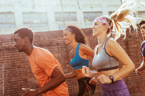 Diverse group of young people running together in the city