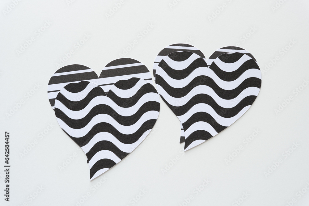 odd looking black and white hearts machine-cut from wavy pattern paper on white