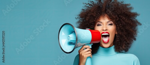 A youthful woman wearing makeup smiling places a plastic megaphone on her head and raises funds She is isolated on a blue background with room for text photo