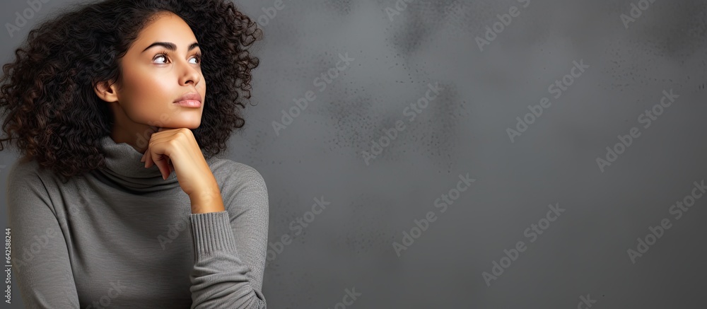 Daydreaming young woman of mixed race wearing casual clothes isolated on gray background looking away and deep in thought - obrazy, fototapety, plakaty 