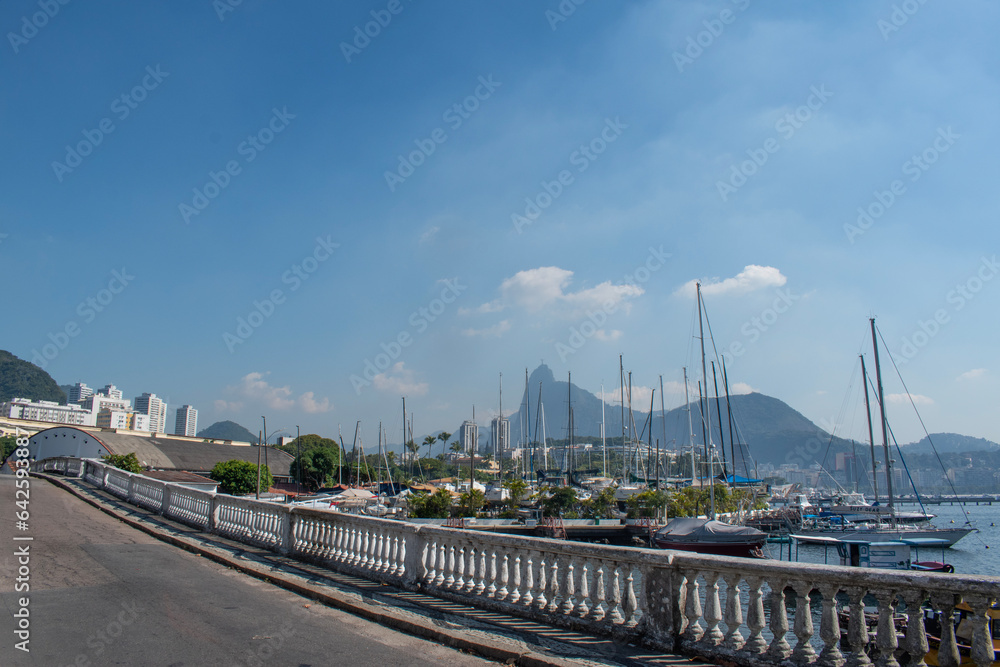 Rio de Janeiro, Brazil: Urca district, view of Guanabara Bay and the harbour for fishing boats with misty city ​​skyline and Christ the Redeemer on Corcovado Mountain on the background 
