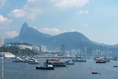 Rio de Janeiro, Brazil: Urca district, plane landing, view of Guanabara Bay and the harbour with misty city ​​skyline and Christ the Redeemer on Corcovado Mountain on the background 