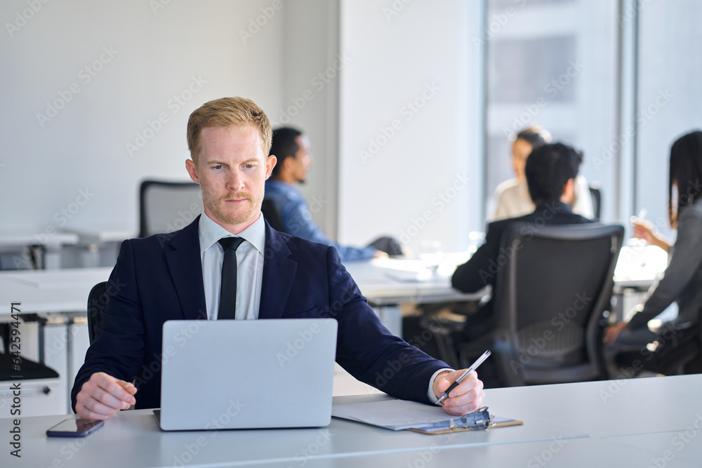 Busy business man manager employee wearing suit using laptop in company office. Young male digital professional worker executive using computer technology watching webinar elearning sitting at desk. Busy business man manager employee wearing suit using laptop in company office. Young male digital professional worker executive using computer technology watching webinar elearning sitting at desk.