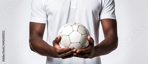 Football player gripping football with both hands over white backdrop