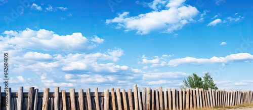 Stockade fence against the blue sky Pointed logs old wood texture