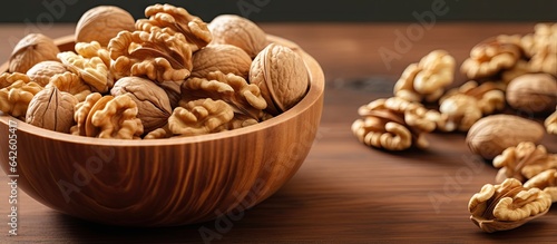 Walnut halves in a wooden bowl close up view colored background Nutritional concept with space for text © vxnaghiyev