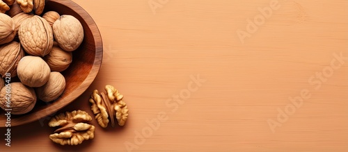 Walnut halves in a wooden bowl close up view colored background Nutritional concept with space for text