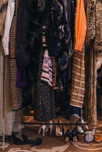 Women's cloth and fur coats hanging in a row on the backstage. Female fashion concept