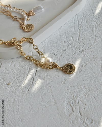 gold chain on a white substrate under the rays of the sun