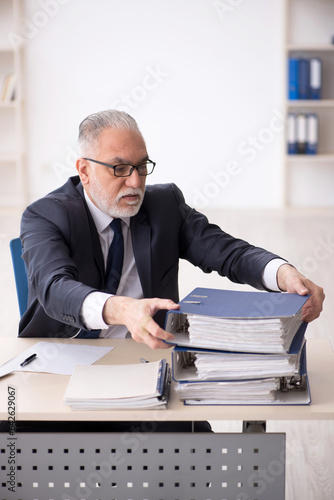 Old male employee working in the office