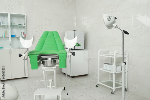 Modern gynecological office interior with examination chair and medical equipment
