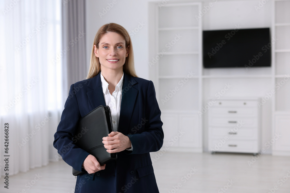 Happy real estate agent with leather portfolio indoors. Space for text Happy real estate agent with leather portfolio indoors. Space for text