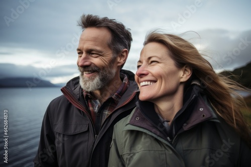 Couple in their 40s smiling at the Loch Ness in Scottish Highlands Scotland