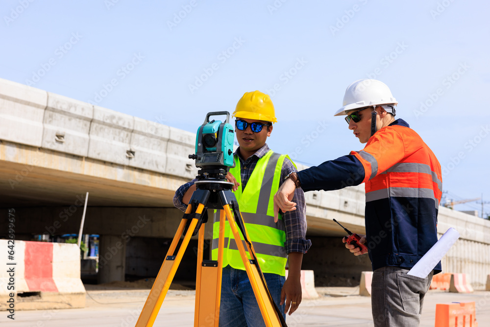 Engineer use theodolite equipment for route surveying to build a bridge across the intersection to reduce traffic congestion during rush hours. . Engineer use theodolite equipment for route surveying to build a bridge across the intersection to reduce traffic congestion during rush hours. .