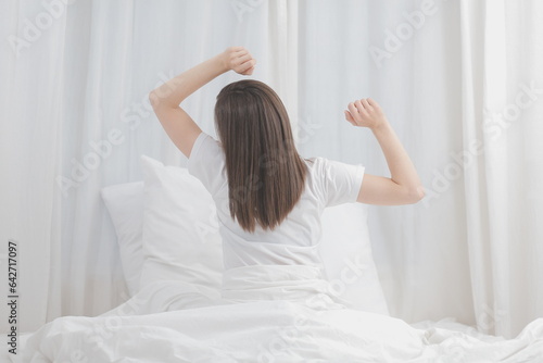 Wallpaper Mural Efficient Young Millennial Girl Sitting on a Bed in the Morning, Uses Laptop Computer and Eats Croissants and Drinks Coffee for Breakfast Torontodigital.ca