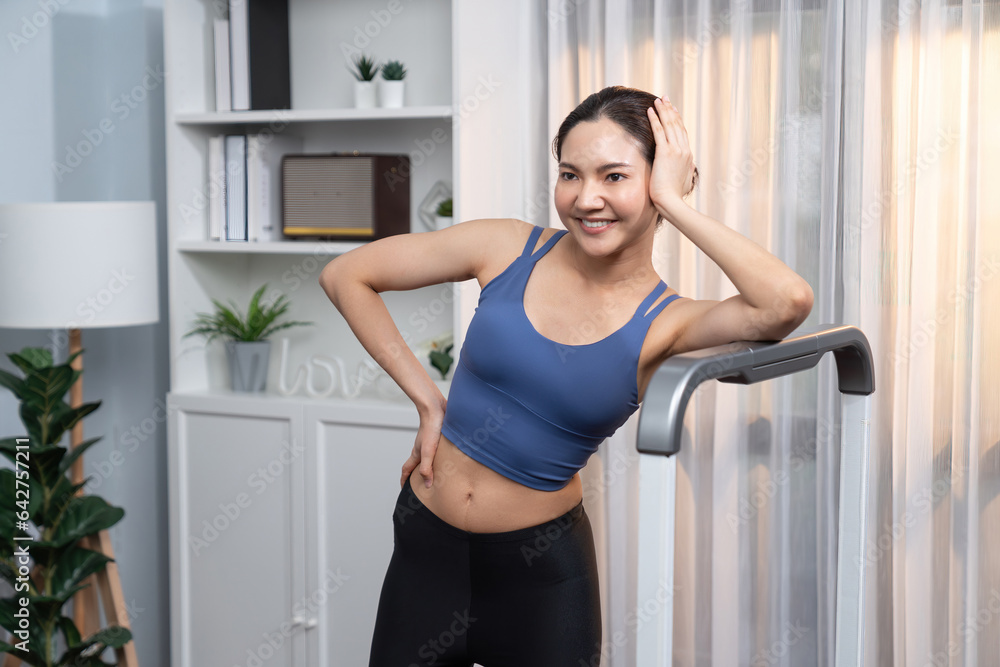 Asian woman in sportswear portrait, smiling and posing cheerful gesture. Home workout training or exercise fitness lifestyle. Attractive girl engage in her pursuit of healthy lifestyle. Vigorous