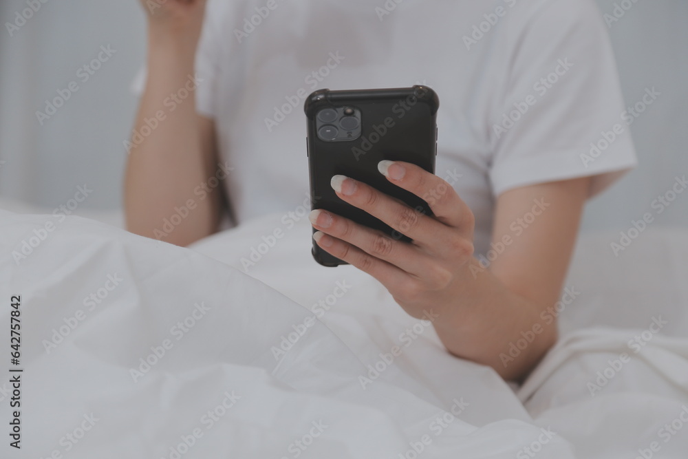 Efficient Young Millennial Girl Sitting on a Bed in the Morning, Uses Laptop Computer and Eats Croissants and Drinks Coffee for Breakfast Efficient Young Millennial Girl Sitting on a Bed in the Morning, Uses Laptop Computer and Eats Croissants and Drinks Coffee for Breakfast
