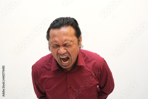 angry expression of asian man isolated on red background