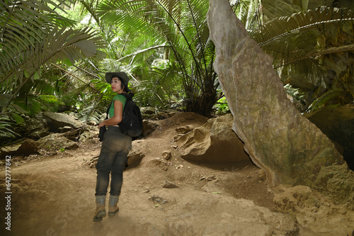 Pretty Asian woman is trekking and traveling At the entrance to Hup Pa Tad Cave and is a popular tourist attraction for Thai tourists Located in Uthai Thani Province, Thailand.