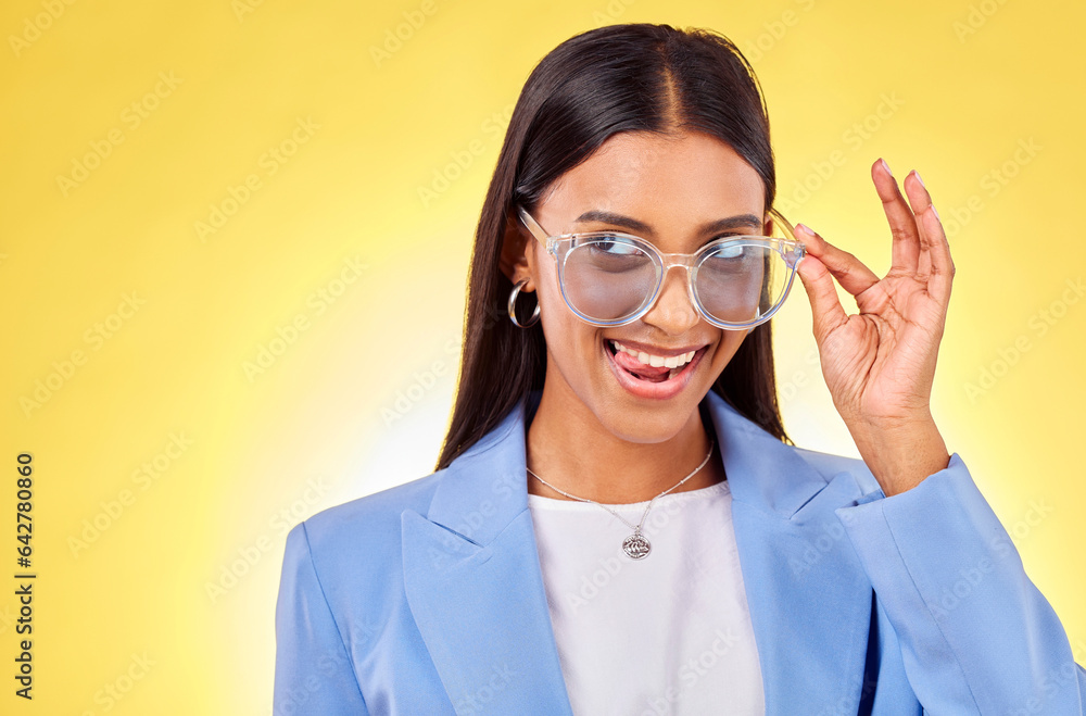 Funny, woman and sunglasses with tongue out, comedy and silly face in a studio. Yellow background, crazy and young female person with modern fashion, trendy cool style and creative work clothing