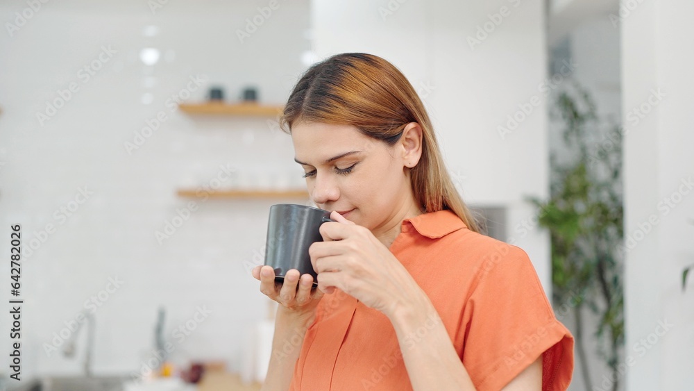 Happy woman relaxing with hot coffee in the morning at home on weekend. Relaxed woman smelling coffee. Woman enjoying breakfast with a cup of coffee. Lifestyle concept Happy woman relaxing with hot coffee in the morning at home on weekend. Relaxed woman smelling coffee. Woman enjoying breakfast with a cup of coffee. Lifestyle concept