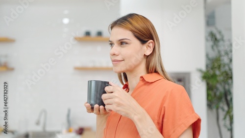 Lifestyle concept. Dreaming young woman enjoy drinking a cup of tea heaping or coffee in the morning at home. woman enjoying breakfast with a cup of coffee
