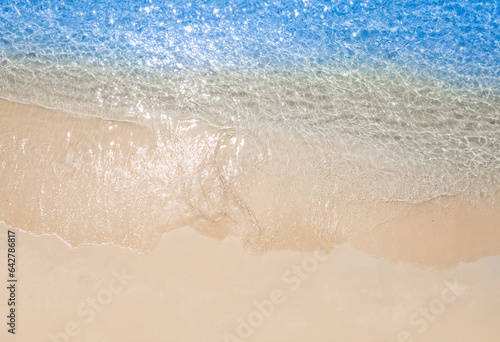 Beach sand background for summer vacation concept. Beach nature and summer seawater with sunlight light sandy beach Sparkling sea water contrast with the blue sky