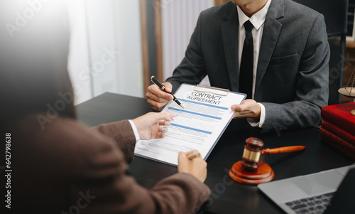 Judge gavel with scales of justice, Business and lawyer or counselor consulting and discussing contract papers with laptop and tablet at law firm in office...