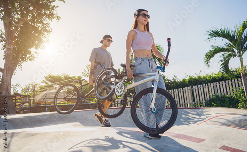 Young happy couple enjoy BMX riding at the skatepark