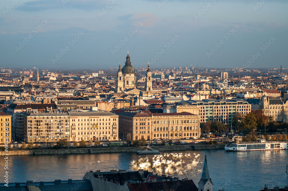 The embankment of the Danube river with the panorama of the city of Budapest. The towers of St. Stephen's Cathedral in the city center.