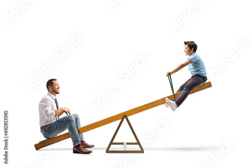 Smiling man and a boy playing on a seesaw
