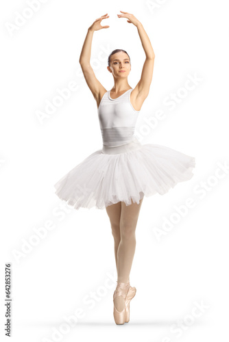 Full length profile shot of a ballerina in a white tutu dress dancing with arms up