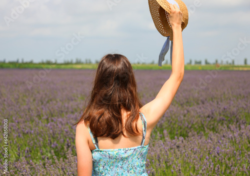 girl with long brown hair and straw boater hat in the lavender field