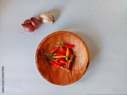 Red chilies, shallots, garlic on wooden plate. isolated on white background photo