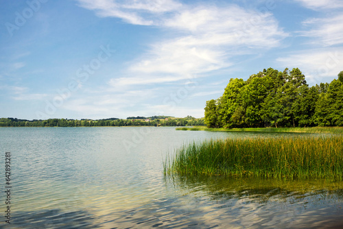 Lake landscape. Summer time background. Szelment Wielki lake in Poland. Blue cloudy sky over water surface panoramic view. Tranquil rural view. Weekend camping.