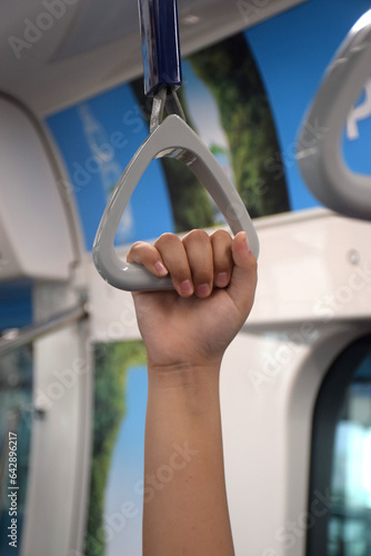 People Hand holding Handle on the train, in commuter train