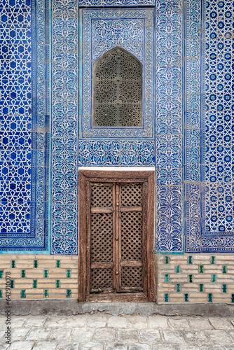Fototapeta Naklejka Na Ścianę i Meble -  Wall of khan palace with carved wooden door and tiles with intricate ornament, Khiva, Uzbekistan