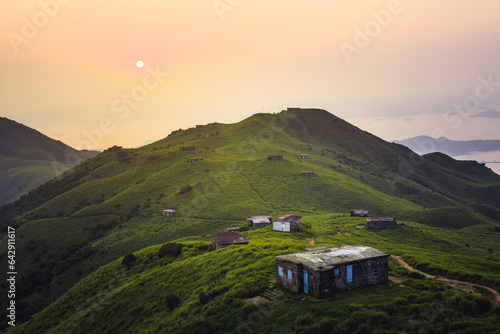 sunset over the mountains with house on the top