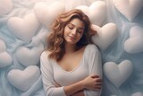 Beautiful blonde woman lying on a bed of white heart-shaped pillows. Top view.