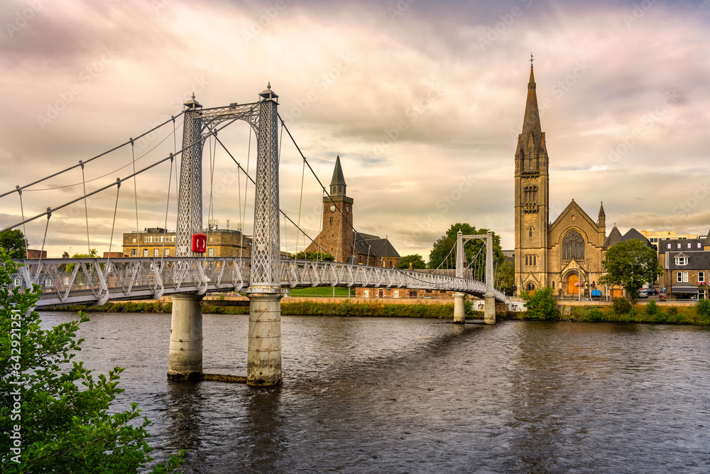 Naklejka premium Suspended walkway that passes over the River Ness in the beautiful city of Inverness at sunset, Scotland.