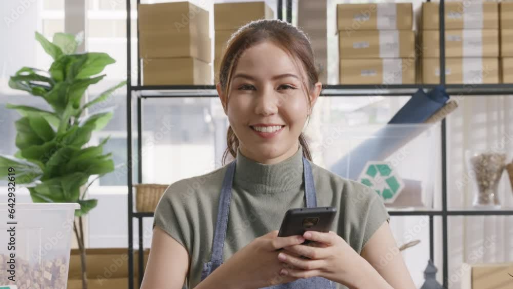 Save the planet earth Eco friendly box in net zero waste store asian seller digital retail office SDGs shop. ESG Small SME owner asia people happy woman vendor smile holding mobile looking at camera. Save the planet earth Eco friendly box in net zero waste store asian seller digital retail office SDGs shop. ESG Small SME owner asia people happy woman vendor smile holding mobile looking at camera.