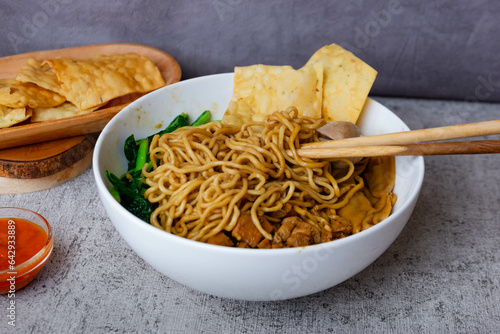 Mie Yamin is a food from Indonesia that tastes delicious. Mie Yamin which is similar to Chicken Noodles with the addition of meatballs, vegetables, boiled and fried dumplings photo