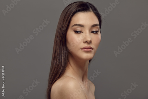 Young lady with oriental appearance, brown eyes, hair.