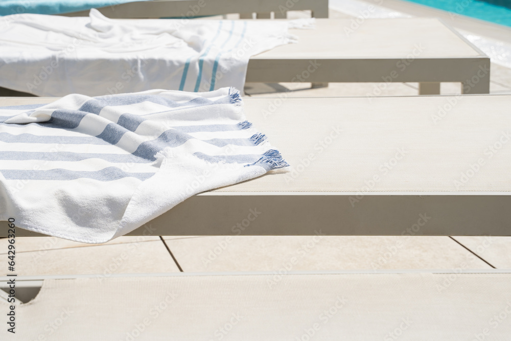 Sun loungers and covers on them near the swimming pool.