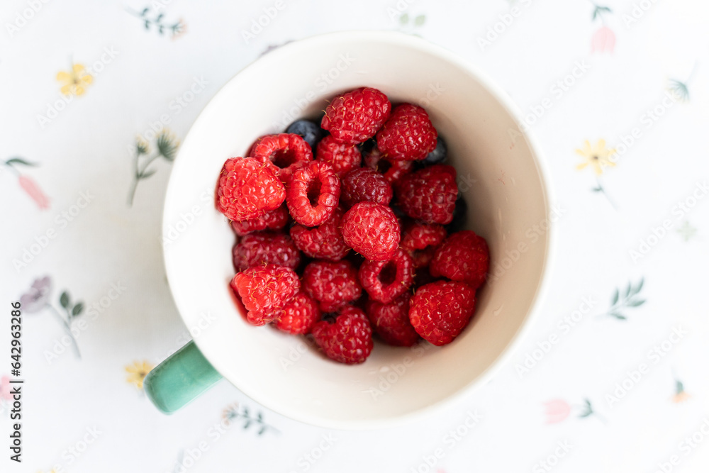 Mix various of summer berries, wild berries in a ceramic bowl, top view.