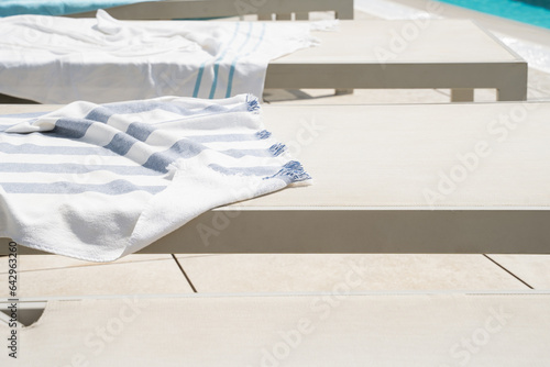 Obraz na płótnie Sun loungers and covers on them near the swimming pool. w salonie
