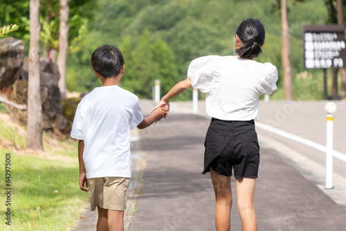 手を繋いで仲良く歩くアジア人の男の子と女の子