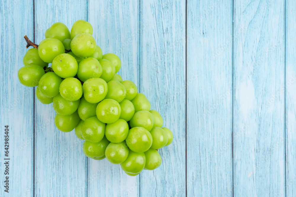 The Japanese Shine Muscat Grape on wooden blue background. The Japanese Shine Muscat Grape on wooden blue background.