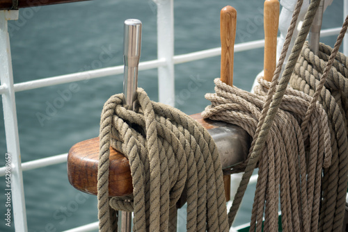 Ship ropes are laid on the rigging of a sailboat against the backdrop of sea waves